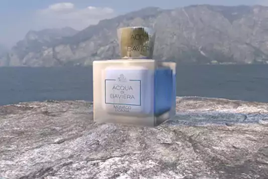 Viereckiges Parfumfläschchen, mit blauer Flüssigkeit. Es steht auf einem verschneiten Fels an der Klippe zu einem Meer und ist selbst auch dezent am Gals gefroren. 3D Parfummodell Design von elfgenpick Werbeagentur.