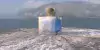 Viereckiges Parfumfläschchen, mit blauer Flüssigkeit. Es steht auf einem verschneiten Fels an der Klippe zu einem Meer und ist selbst auch dezent am Gals gefroren. 3D Parfummodell Design von elfgenpick Werbeagentur.